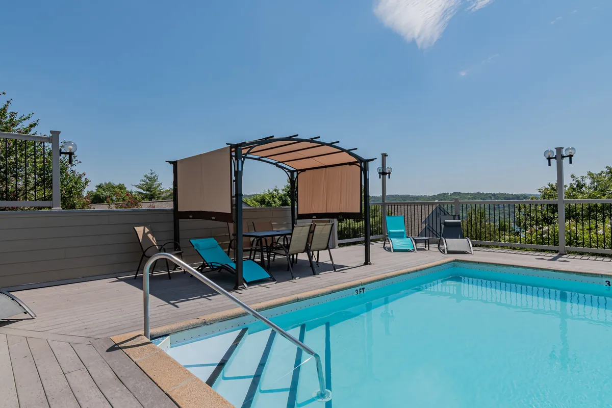 A welcoming outdoor swimming pool with inviting lounge chairs, a canopy for shade, and a beautiful landscape in the background. The pool area feels vibrant and social, ideal for groups to relax after a day of exploring.