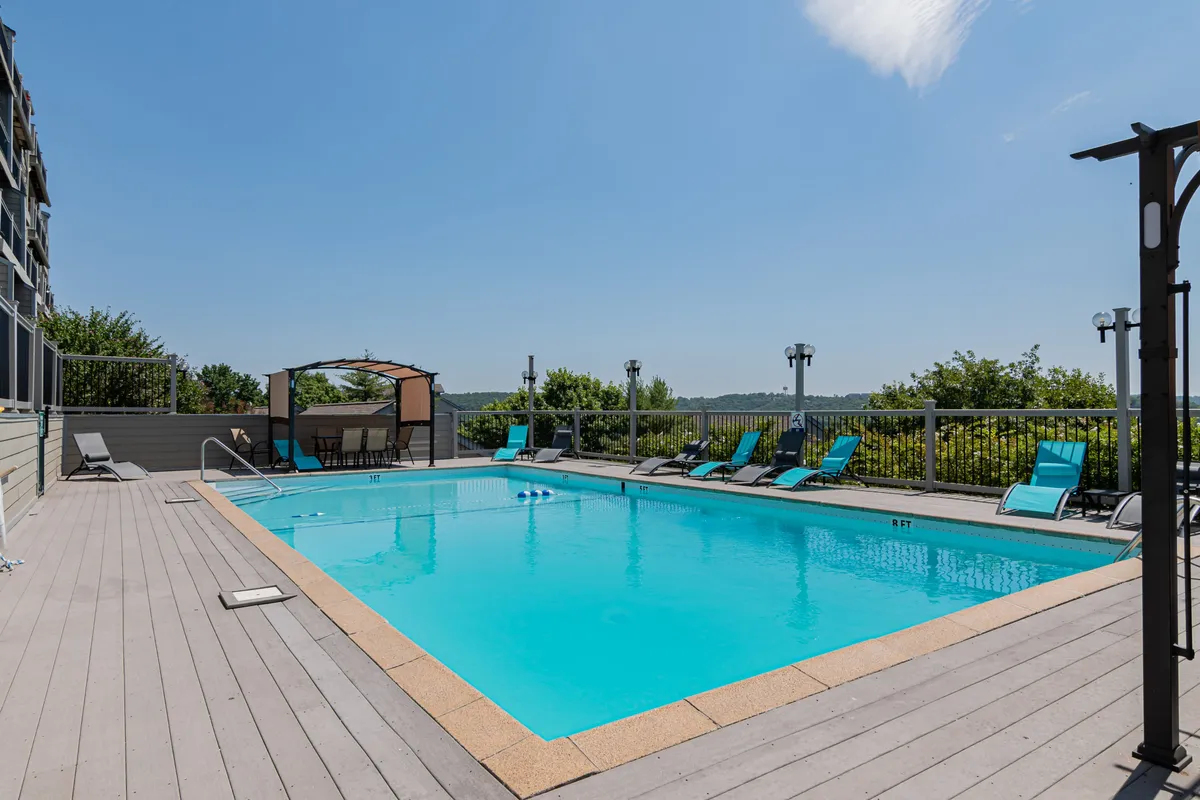 This image captures the sparkling outdoor swimming pool surrounded by lounge chairs and a cabana, inviting guests to relax and unwind after a day at the theme park. The setting suggests a fun, social atmosphere ideal for families, with plenty of space for both play and relaxation.